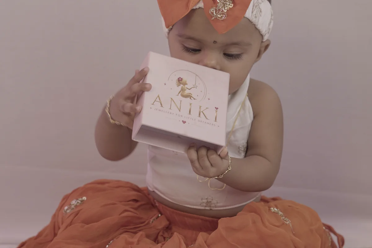 Toddler opening an ANIKI jewellery gift box
