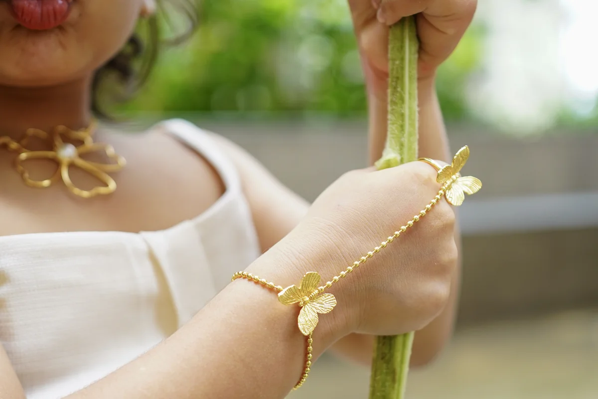 Close up of a child wearing a gold-finish ANIKI bracelet on her wrist