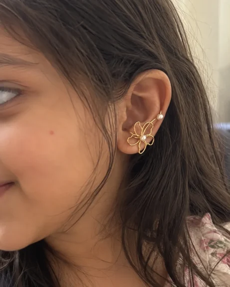 The ANIKI Golden Pearl Flower Ear Cuff on a little ear