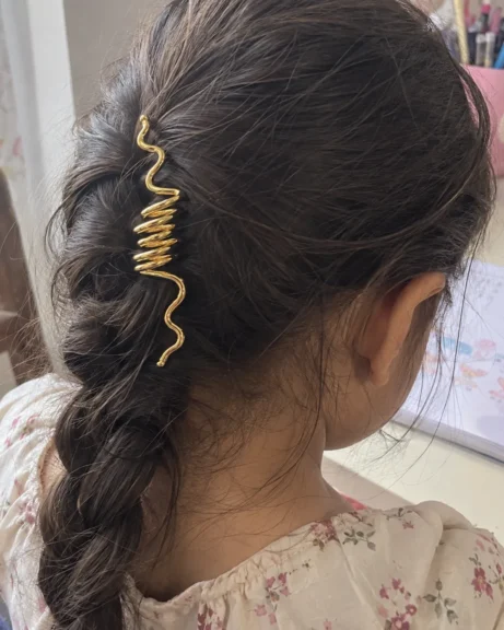 Child wearing the ANIKI Golden Wave Hair Accessory