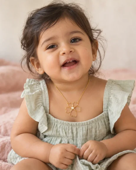 Little one smiling in the ANIKI Pearl Blossom Pendant